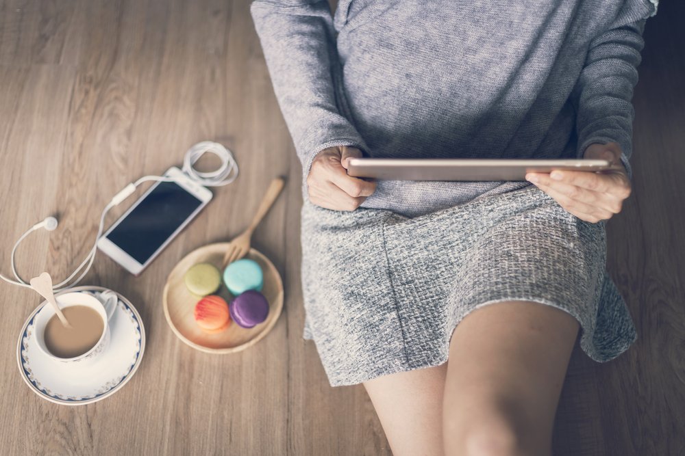 Žena držící tanlet a sedící na podlaze FEEL WOOD